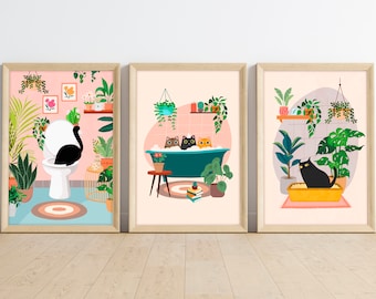 May include: Three framed illustrations of a bathroom with a cat in each scene. The first shows a black cat sitting on a toilet. The second shows three cats in a bathtub with bubbles. The third shows a black cat sitting in a litter box. Each scene features a pink background with green plants.