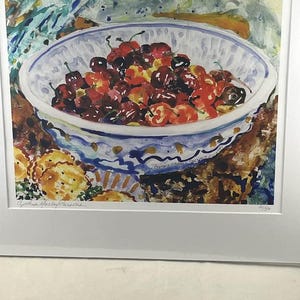 May include: Watercolor painting of a bowl filled with cherries. The bowl is white with a blue patterned rim. The cherries are a mix of red and dark red. The painting is signed by the artist.