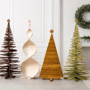 May include: Four decorative wooden Christmas trees standing in a row. The first is dark brown, the second is a light natural wood spiral, the third is a solid golden-brown triangular shape, and the fourth is a green tree, all topped with stars.