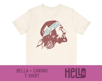 Könnte beinhalten: Ein beiges T-Shirt mit einer Vintage-Illustration eines Kopfes, der ein Bandana mit dem Text "Make America Cowboy Again" trägt.