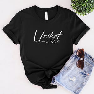May include: Black t-shirt with white text that says "Unikat" with a small heart symbol.