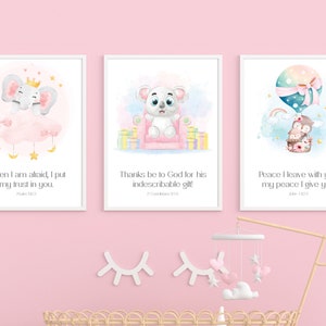 Peut inclure: Trois impressions encadrées à l'aquarelle avec des illustrations d'animaux pour bébés. Les impressions présentent un éléphant, un ours et des hiboux dans une montgolfière. Chaque impression contient une citation de la Bible. Le fond est rose clair.