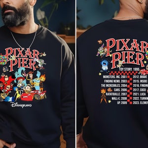 May include: Black sweatshirt with a graphic of Pixar characters and the text "Pixar Pier Disneyland" on the front. The back of the sweatshirt features the text "Pixar Pier" with a list of Pixar movies and their release years.