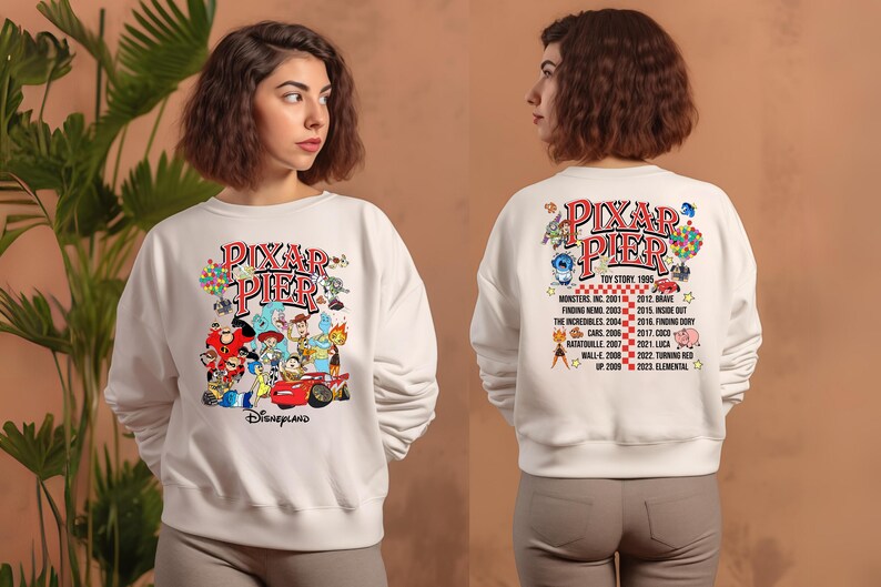 May include: White sweatshirt with a colorful graphic of Pixar characters and the text "Pixar Pier" and "Disneyland". The back of the sweatshirt has a list of Pixar movies and their release years.