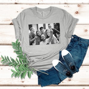 May include: A gray t-shirt with a black and white photo of a group of friends taking a selfie. The photo shows six people smiling and looking at the camera.