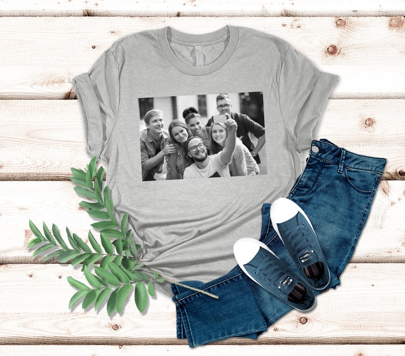 May include: A gray t-shirt with a black and white photo of a group of friends taking a selfie. The photo shows six people smiling and looking at the camera.