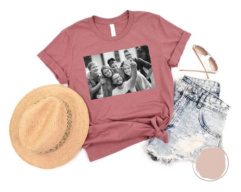 May include: A maroon t-shirt with a black and white photo of a group of friends taking a selfie. The photo shows six people smiling and looking at the camera.