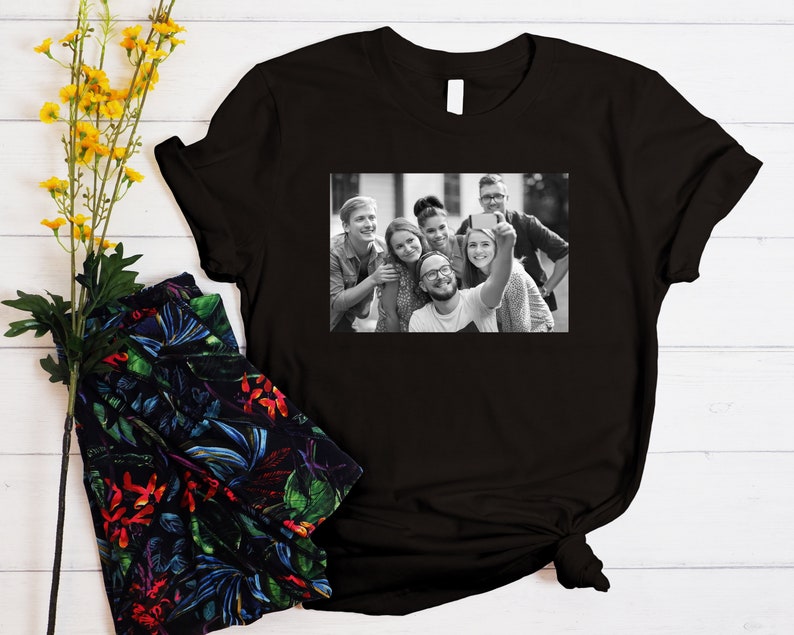 May include: Black and white photo of a group of friends taking a selfie. The photo is printed on a black t-shirt.