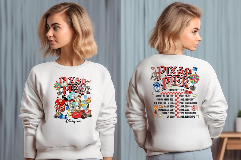 May include: White sweatshirt with a colorful graphic of Pixar characters and the text "Pixar Pier" on the front. The back of the sweatshirt has a list of Pixar movies and their release dates.