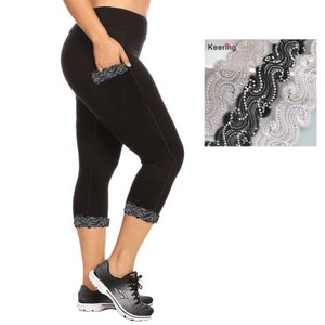 May include: Black cropped leggings with lace trim at the bottom and a lace pocket on the left leg. The leggings are worn by a person with black shoes. The image also includes a close-up of black and white lace trim.