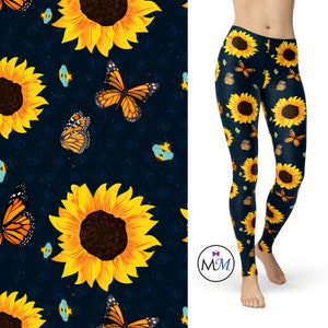 May include: Black leggings with a repeating pattern of yellow sunflowers, orange butterflies, and blue bees on a dark blue background.