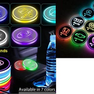 May include: Illuminated LED car coasters displaying car brand logos such as Kia, Audi, and Ford. The coasters, available in multiple colours, feature the text "All Car Brands" and "Available in 7 colours".
