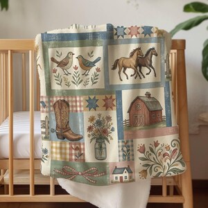 May include: A soft throw blanket featuring a patchwork design with illustrations of two birds, two horses, a cowboy boot, a red barn, a house, and a mason jar filled with flowers, all set against a cream background with blue and green accents.