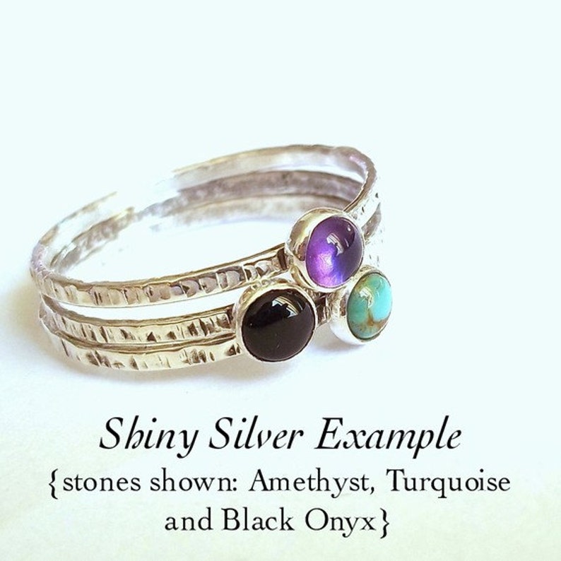 May include: Three silver stacking rings with hammered texture. The rings are adorned with small gemstones: amethyst, turquoise, and black onyx.  {stones shown: Amethyst, Turquoise and Black Onyx}