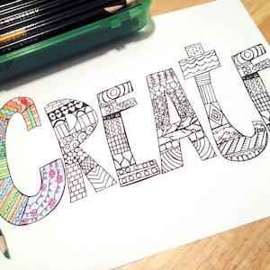 Op de afbeelding: Een kleurplaat met het woord "CREATE" in grote, gestileerde letters met ingewikkelde patronen. De letters zijn zwart omlijnd en klaar om in te kleuren.