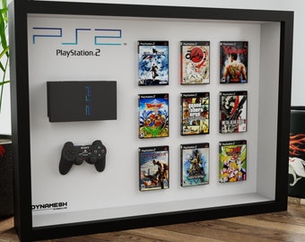 May include: A framed display featuring a PlayStation 2 console, controller, and game cases. The black frame holds the console, controller, and game cases, with the PlayStation 2 logo at the top. The games include titles like Dragon Quest and Grand Theft Auto.