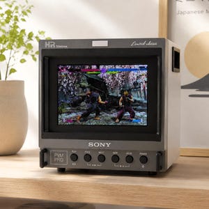 Peut inclure: Un moniteur Sony PVM PRO Trinitron gris affichant un jeu vidéo de combat sur son écran. L'appareil présente un cadre noir, une série de boutons de commande circulaires étiquetés play, prev, next, incr, decr, power et une étiquette limited edition.