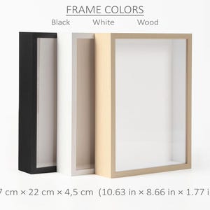 May include: Three shadow box frames in black, white, and wood colors. The frames are rectangular with a recessed interior. The dimensions are 10.63 inches x 8.66 inches x 1.77 inches. The text "FRAME COLORS" is at the top.
