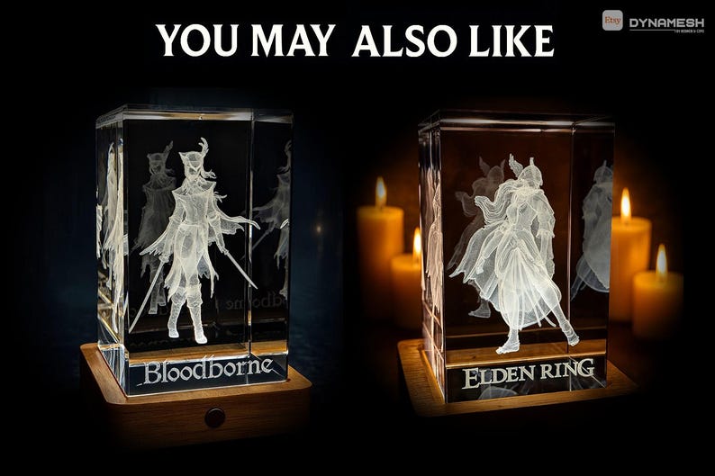 May include: Two illuminated glass cubes with engraved figures, one labeled "Bloodborne" and the other "Elden Ring." The cubes sit on wooden bases, with candles in the background. The text "YOU MAY ALSO LIKE" is at the top.