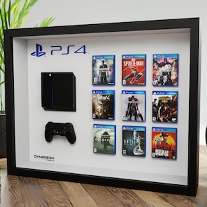 Peut inclure: Un cadre vitrine noir présentant une console, une manette de jeu noire et neuf boîtiers de jeux miniatures.