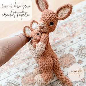 May include: A crocheted kangaroo and joey in shades of brown and beige. The larger kangaroo holds the smaller joey in its pouch. The text "2-in-1 low sew crochet pattern" is visible in the upper left corner.