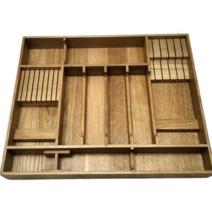 Könnte beinhalten: Ein hölzernes Bestecktablett mit mehreren Fächern zur Organisation von Besteck. Das Tablett ist aus hellem Holz gefertigt und verfügt über Schlitze für Messer, Gabeln und Löffel. Das Design umfasst unterschiedlich große Fächer für verschiedene Utensilien.