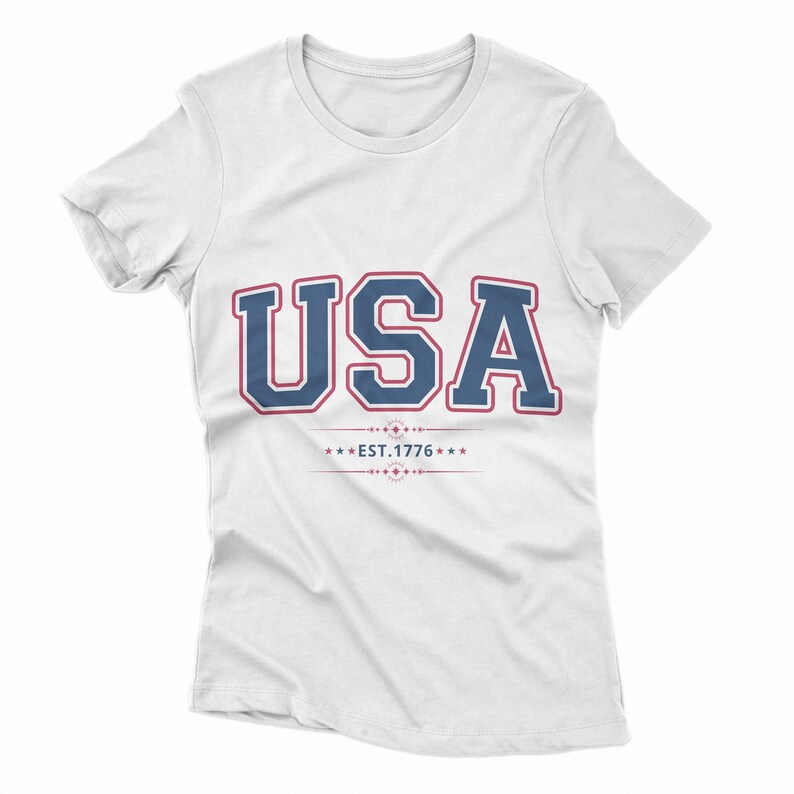 May include: White t-shirt with a blue and red graphic that says "USA EST. 1776" in a vintage collegiate style.