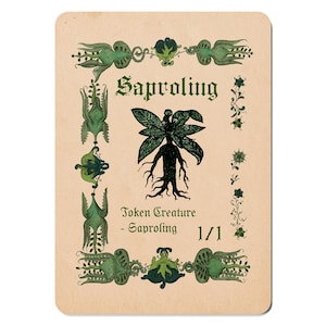 May include: A vintage-style card with a green and black illustration of a tree-like creature, labelled "Saproling" in green. The card has green floral decorations and the text "Token Creature - Saproling 1/1".