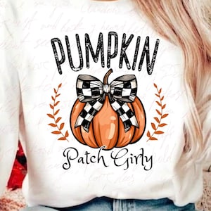 K&ouml;nnte beinhalten: Wei&szlig;er Pullover mit einer schwarz-wei&szlig;en karierten Schleife auf einem K&uuml;rbis mit dem aufgedruckten Text "Pumpkin Patch Girly".
