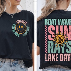 May include: Black t-shirt with a graphic print of a smiley face and the text "Boat Waves Sun Rays Lake Days".