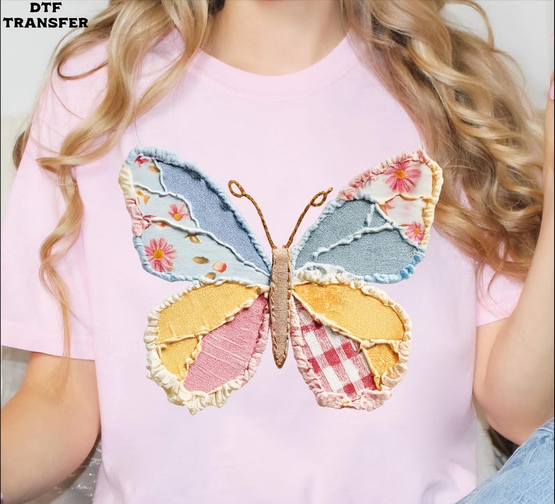 May include: A light pink t-shirt featuring a large, colorful butterfly applique. The butterfly has wings made of patchwork fabrics in shades of blue, yellow, pink, and red, with floral and plaid patterns. The text "DTF TRANSFER" is in the top left corner.