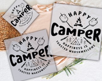 May include: Two white heat transfer vinyl sheets with black text and graphics that read "Happy Camper Happiness is Toasted Marshmallows". The design includes a campfire, tent, and marshmallows on sticks.