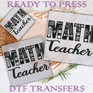 May include: White DTF transfers with the words "MATH Teacher" in a bold, black font. The word "MATH" is designed with math symbols. The text "READY TO PRESS" and "DTF TRANSFERS" are also visible.