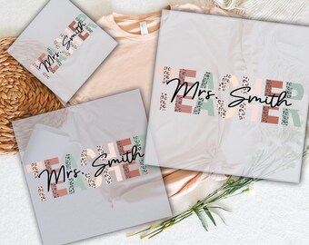 May include: DTF transfers with the text "READY TO PRESS" and "DTF TRANSFERS". The transfers feature the words "TEACHER Mrs. Smith" in a mix of colors and patterns, including leopard print. The transfers are displayed on a light-colored background.