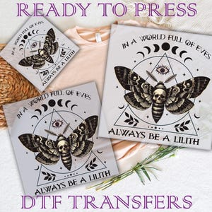May include: DTF transfers with a black and white moth design incorporating a skull, eye, and crescent moon symbols. The text reads "IN A WORLD FULL OF EVES" and "ALWAYS BE A LILITH". The words "READY TO PRESS" and "DTF TRANSFERS" are also visible.
