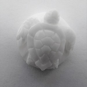May include: White ceramic sculpture of a turtle with a detailed shell and a smooth, rounded body.