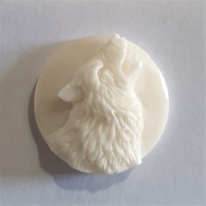 May include: White ceramic pendant featuring a detailed carving of a wolf howling at the moon.