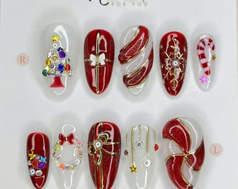 May include: A set of ten Christmas-themed press-on nails. Designs include a Christmas tree, candy cane, bows, and swirling patterns in red, white, and gold. The text "Nailbox for You" is at the top, with "Thank you for choosing us" at the bottom.