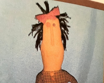 May include: A handmade rag doll with black yarn hair, a pink bow, and a brown plaid shirt.