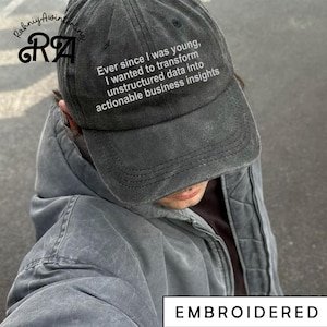 May include: A dark grey baseball cap with the embroidered text: "Ever since I was young, I wanted to transform unstructured data into actionable business insights." The word "EMBROIDERED" is at the bottom.