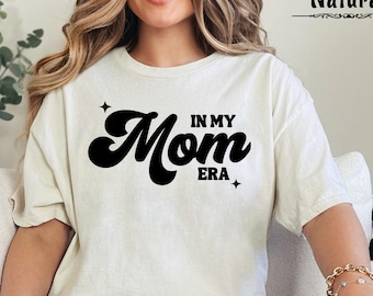 May include: A white t-shirt with a black retro-style graphic that says "In My Mom Era".