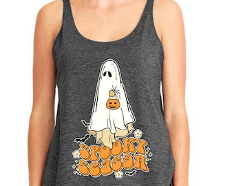 May include: Charcoal gray tank top featuring a white ghost holding a pumpkin-shaped treat bag. The words "Spooky Season" are printed in orange with decorative elements. A fun, festive design for Halloween.