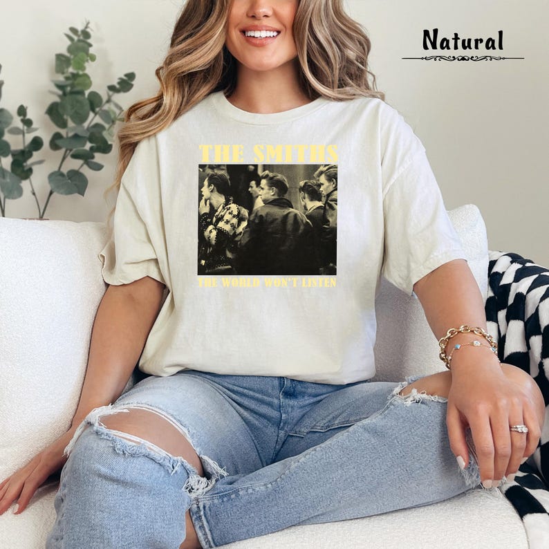May include: A white t-shirt with a black and white image of a band, The Smiths, with the text "The World Won't Listen".