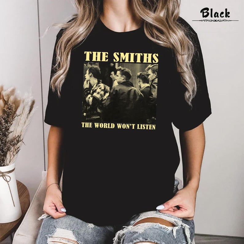 May include: Black t-shirt with a vintage-style graphic of the band The Smiths. The graphic features a black and white photo of the band members and the text "The Smiths" and "The World Won't Listen".
