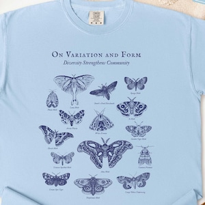 May include: A white ceramic mug with a black handle and the text "But First, Coffee" in a bold, black font. The mug is filled with a dark liquid, likely coffee, and sits on a light-colored surface.