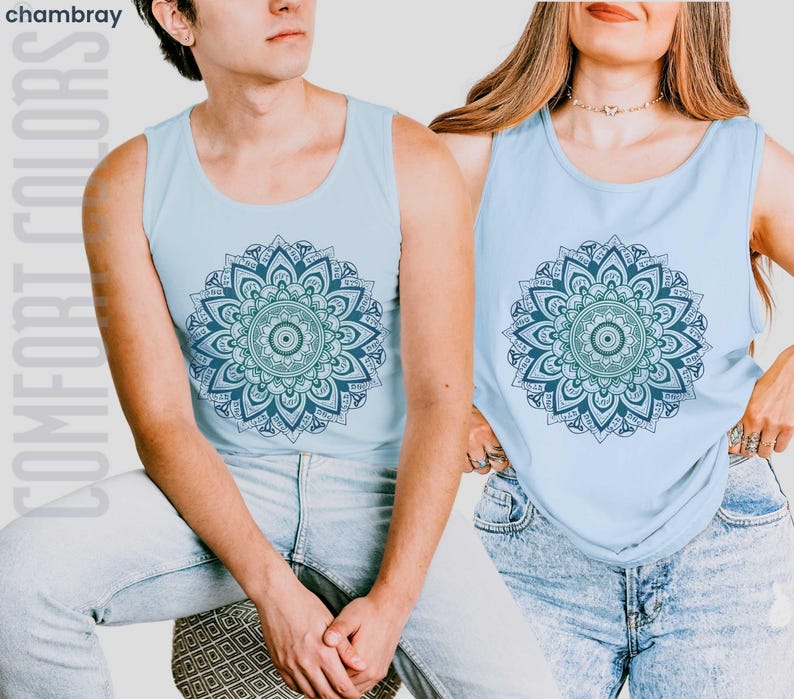 Man and woman in comfort colors 9360 chambray (light blue) tank top sleeveless tee with mandala graphic in blues and greens. Mandala contains hidden FDT, 8647, RESIST, and symbols of pro-choice.