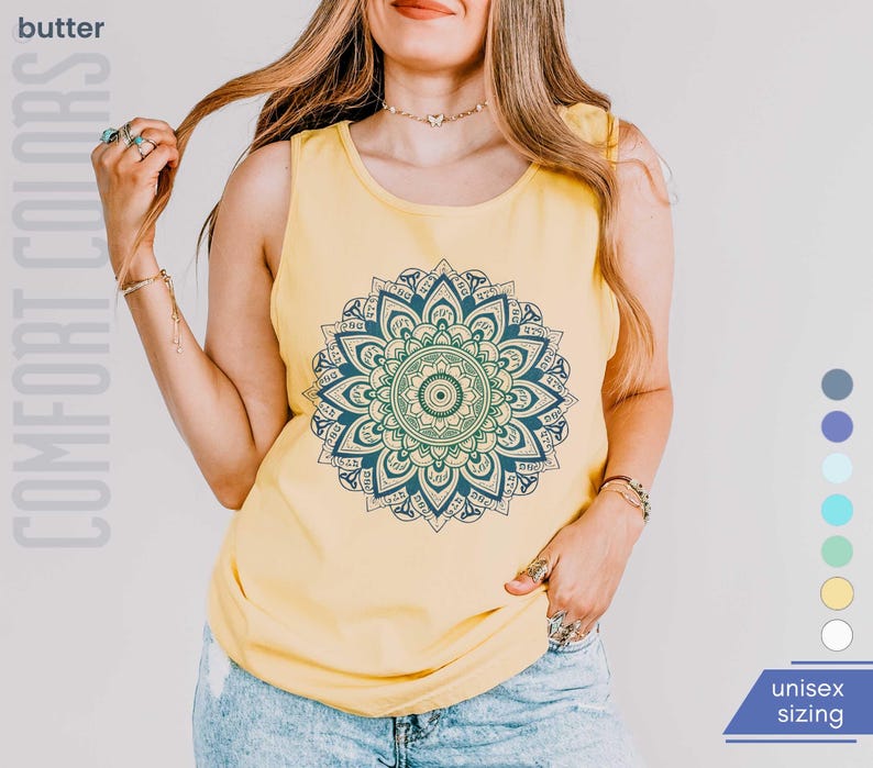Woman in comfort colors 9360 butter yellow tank top sleeveless tee with mandala graphic in blues and greens. Mandala contains hidden FDT, 8647, RESIST, and symbols of pro-choice.