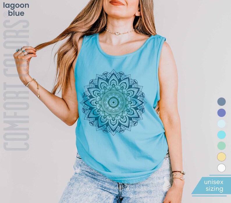 Woman in comfort colors 9360 lagoon blue (medium bright aqua blue) tank top sleeveless tee with mandala graphic in blues and greens. Mandala contains hidden FDT, 8647, RESIST, and symbols of pro-choice.