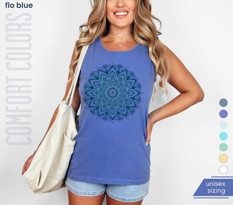 Woman in comfort colors 9360 flo blue (medium bright blue) tank top sleeveless tee with mandala graphic in blues and greens. Mandala contains hidden FDT, 8647, RESIST, and symbols of pro-choice.