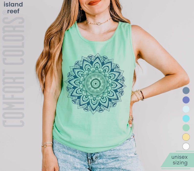 Man and woman in comfort colors 9360 island reef (light greenish aqua) tank top sleeveless tee with mandala graphic in blues and greens. Mandala contains hidden FDT, 8647, RESIST, and symbols of pro-choice.